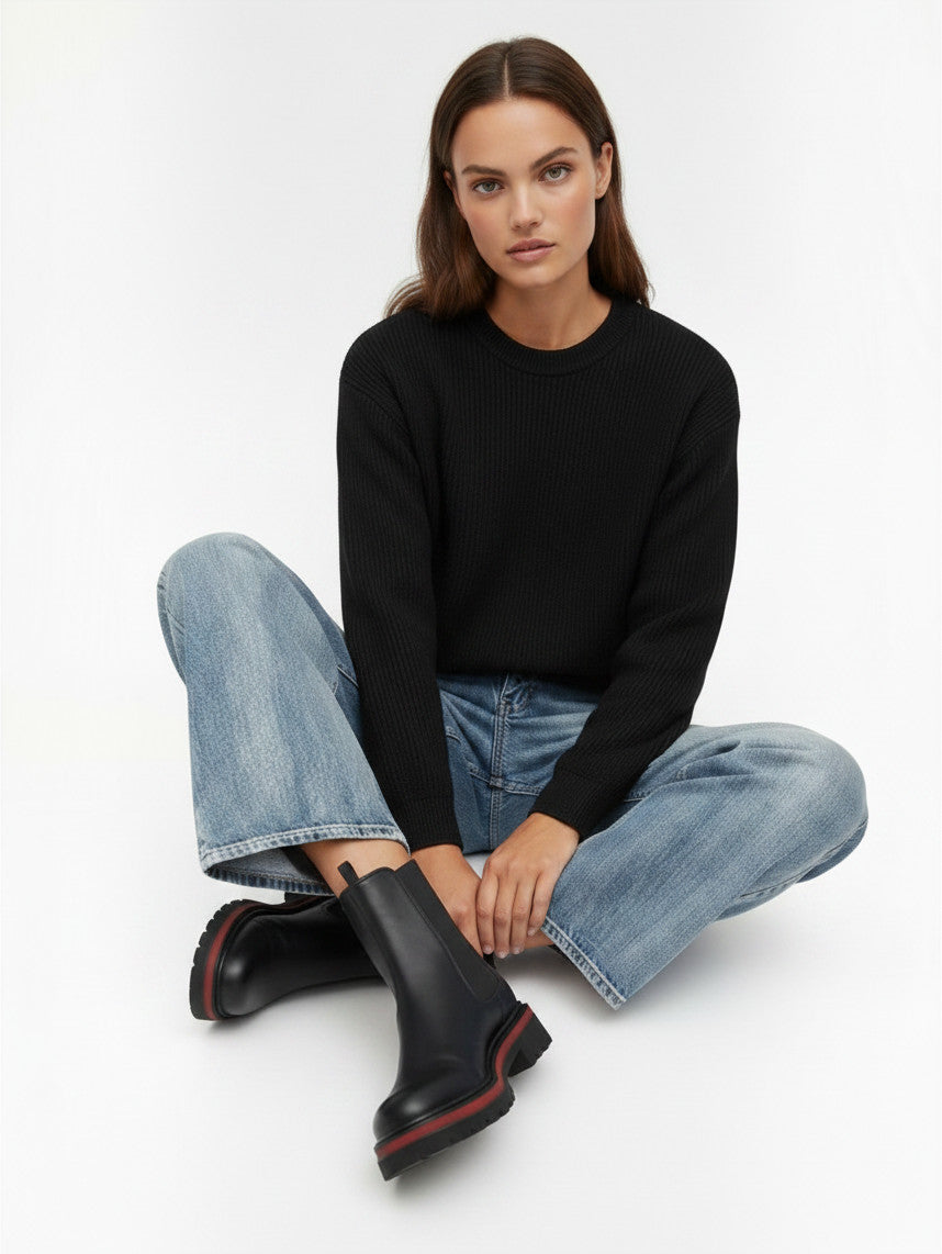 Modèle portant des bottines Chelsea Clueless Paris en cuir noir avec semelle épaisse crantée et détails rouges