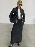 Clueless Paris charcoal grey textured knit zip-up jacket and matching long skirt set worn with a black handbag