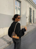 Clueless Paris compact checkered handbag with camel synthetic leather trim and gold chain strap worn by a woman