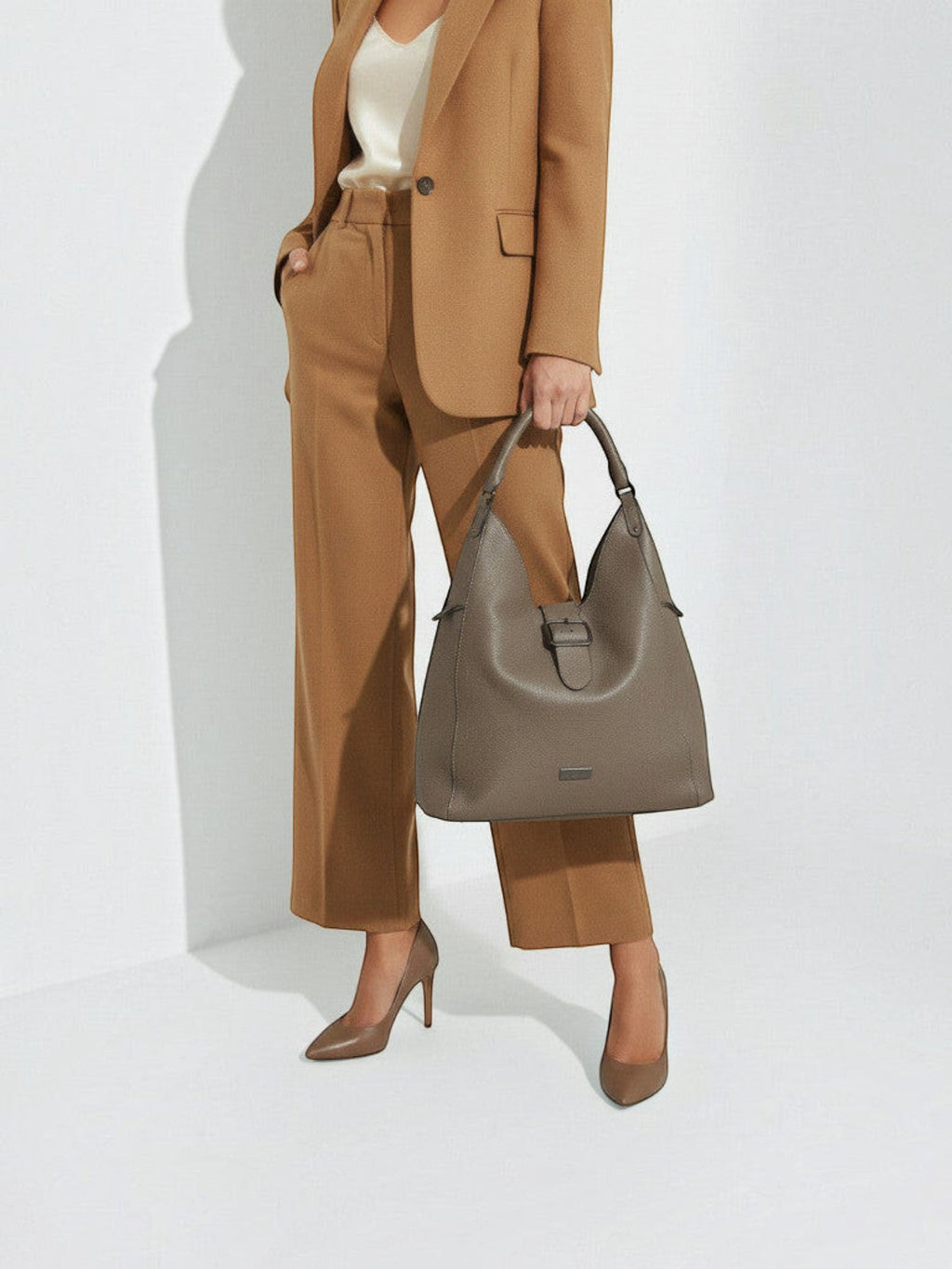 Clueless Paris Georges Rech taupe grained faux leather hobo bag held by a woman in a matching brown suit