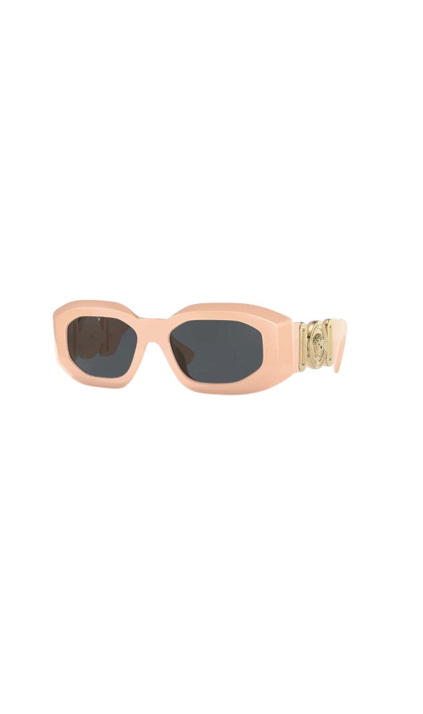 Lunettes de soleil Versace Biggie rose pâle avec monture oversized et médaillon doré emblématique chez Clueless Paris