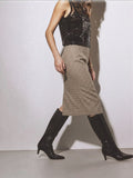 Clueless Paris midi skirt in neutral plaid with a side slit, worn with black knee-high boots and a sequin top.