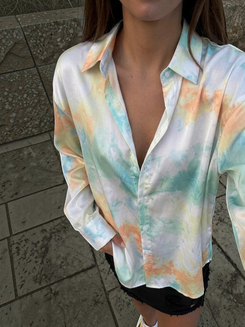 Clueless Paris long-sleeve satin blouse in a pastel blue, peach, and yellow tie-dye print with a classic collar.