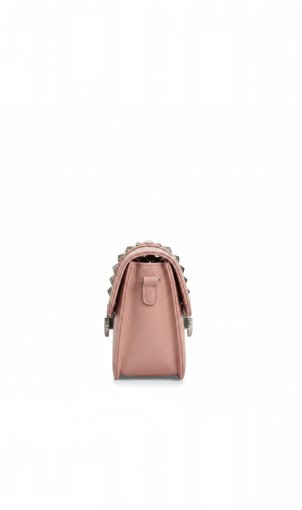 Sac à bandoulière Clueless Paris rose poudré en cuir synthétique avec détails cloutés sur le rabat, vue de profil.