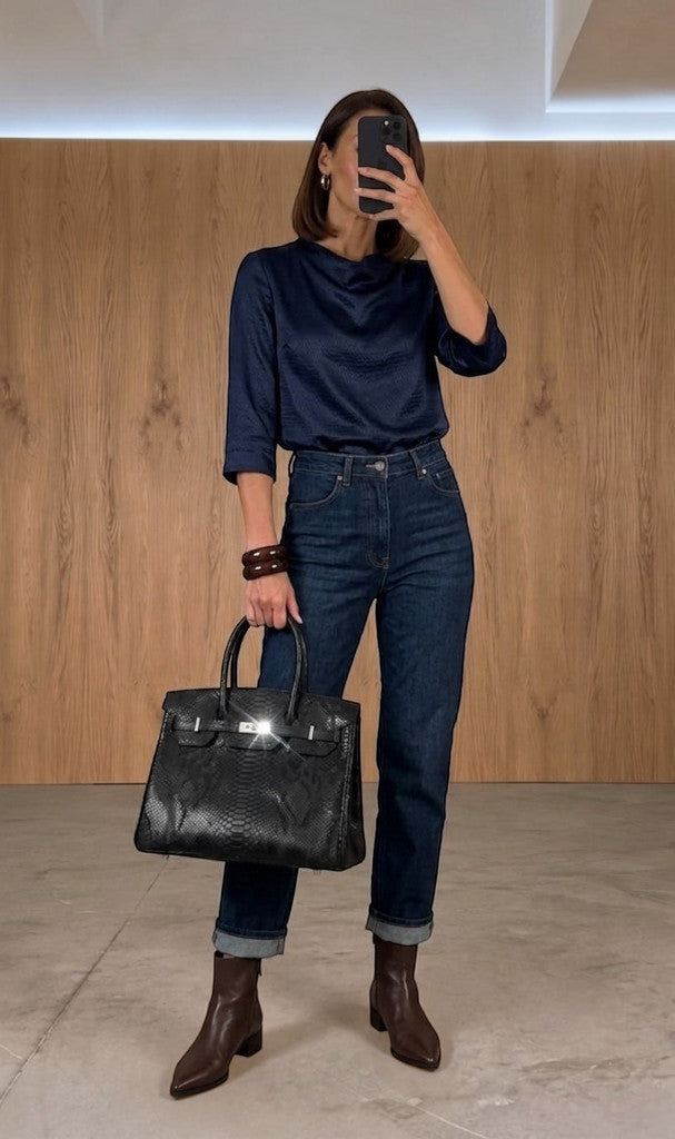 Femme portant un sac à main Clueless Paris en cuir noir texturé façon serpent avec des finitions métalliques
